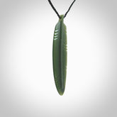 A hand carved large New Zealand Jade feather necklace. The cord is a black colour and is a fixed length. A large sized hand made Jade feather necklace by New Zealand artist Kerry Thompson. One off work of art to wear.